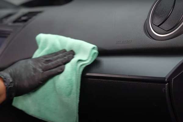 wiping the dash surface with a cloth